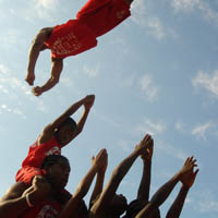 A Jesse White Tumbler skyrockets over 5 of his teammates.